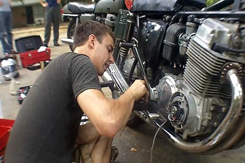 A guy working on a motorcycle